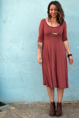 Meg wearing a clay Stasia Dress against a blue wall