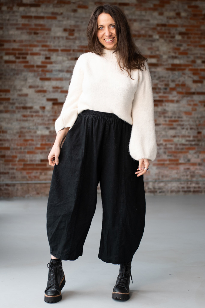 Meg McElwee wearing black Arthur Pants and a white knit top