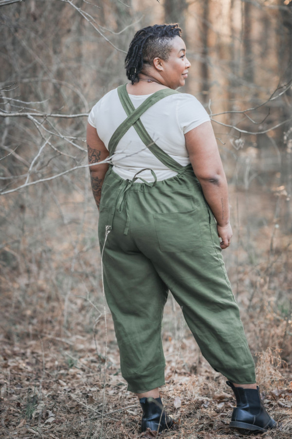 Ashley wears a creams short sleeved tee and olive green otis overalls