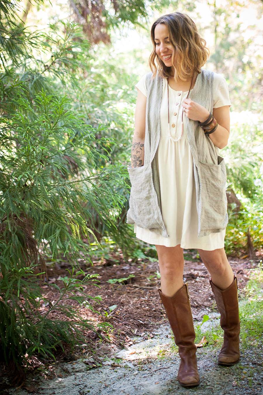 Meg wears a striped Forager Vest over a white Hinterland Dress