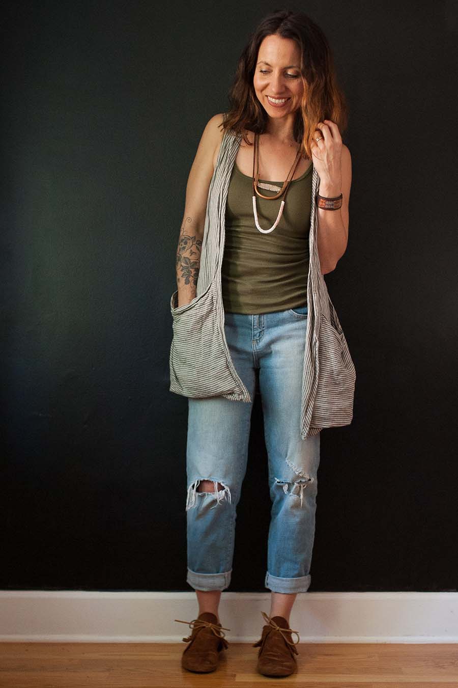 Meg wears a Forager Vest over a tank top and jeans
