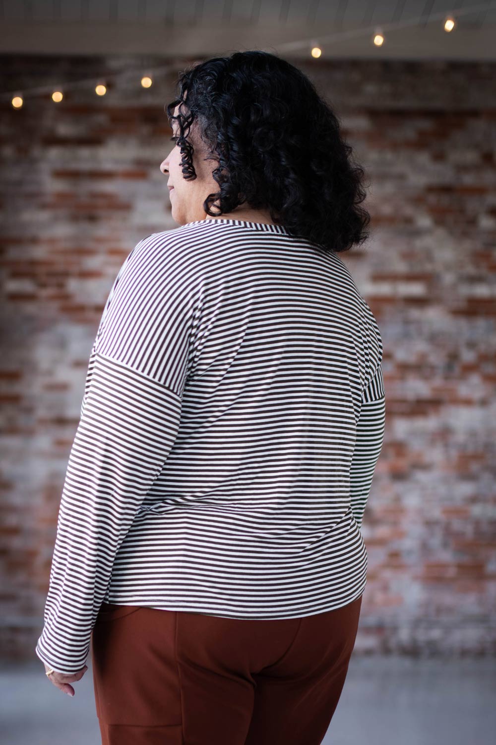 Sudi-Laura models a striped Bedrock Tee, showing the back.