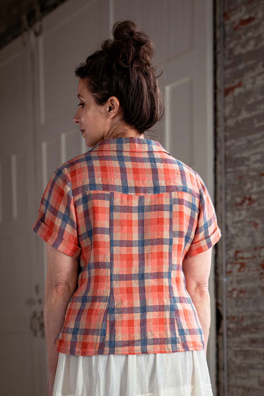 Meg wearing a red plaid, view a Joanie Top