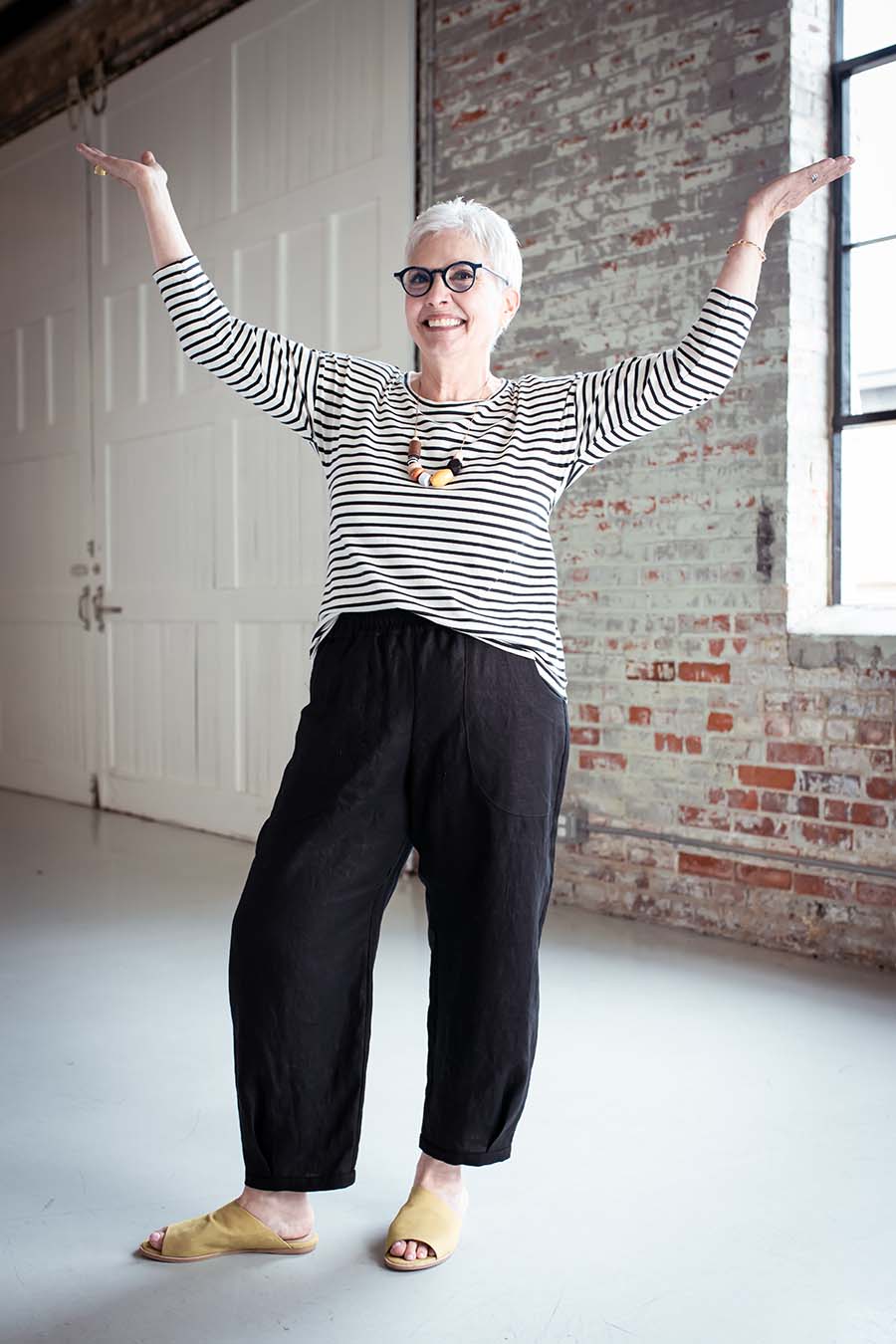 Cindy wears black chanterelle pants and a striped top