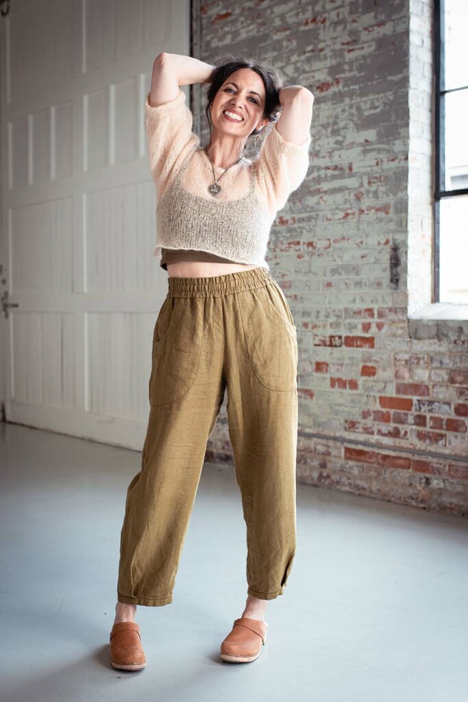 Meg wears olive chanterelle pants and a fuzzy cream top