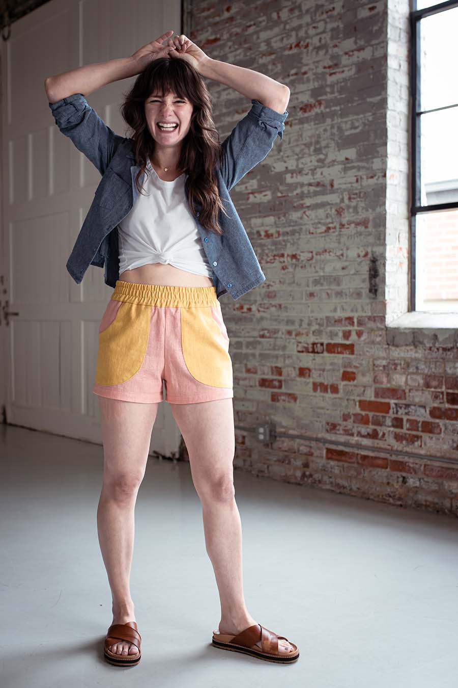 Meredith wears pink and yellow color blocked chanterelle shorts and chambray joanie top