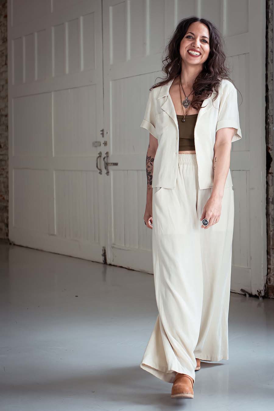 Meg wearing cream view a chanterelle pants and. cream jonie top over an olive tank