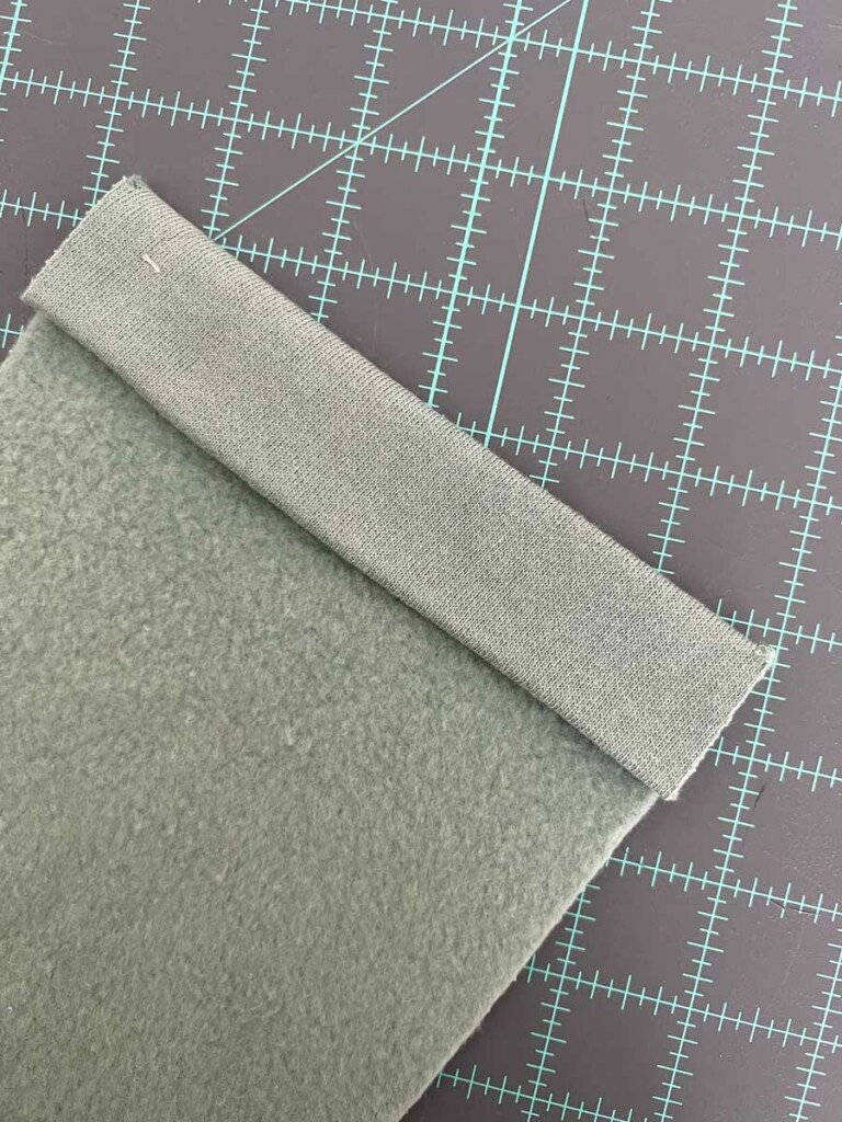 the back pocket piece with the top edge folded another 5/8 inch to the wrong side. 