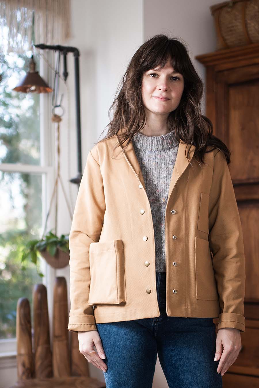 Meredith wears a chestnut Sylvan Jacket, standing in Meg's studio.